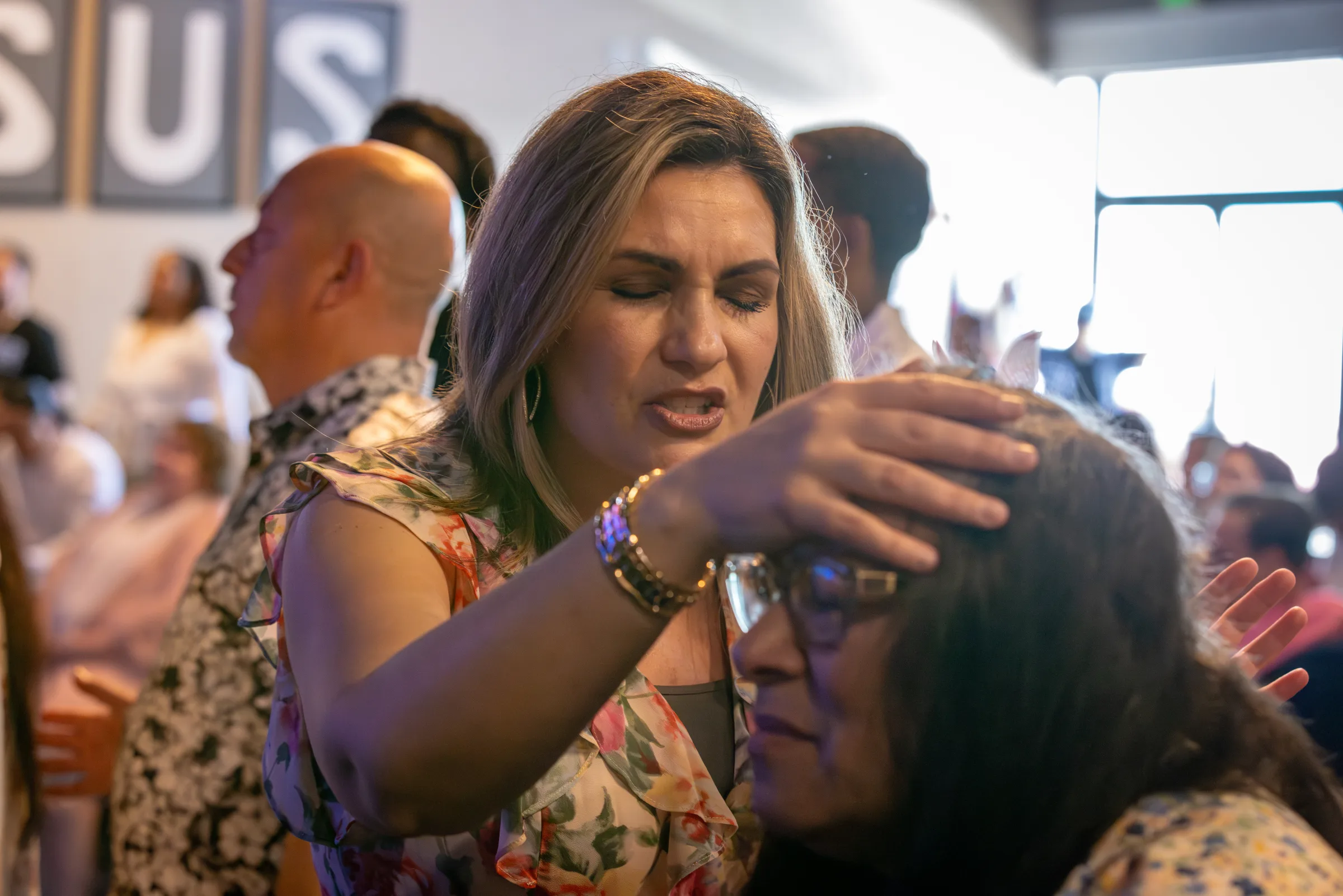 Pastor Hannah praying with a woman