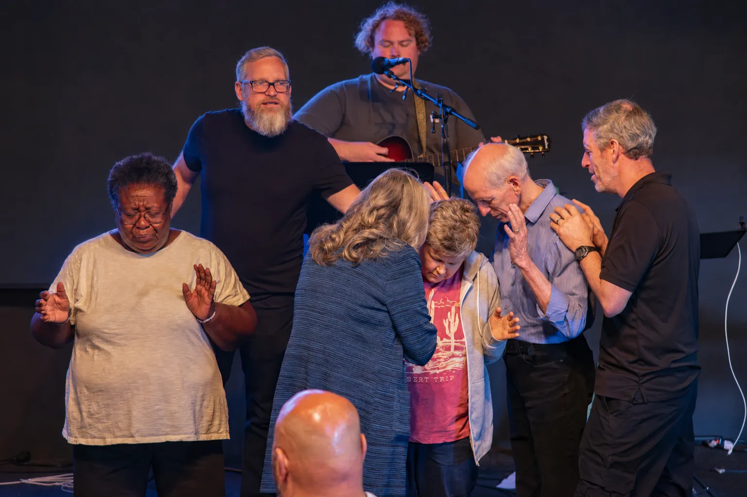 The River Northwest family praying together at the altar