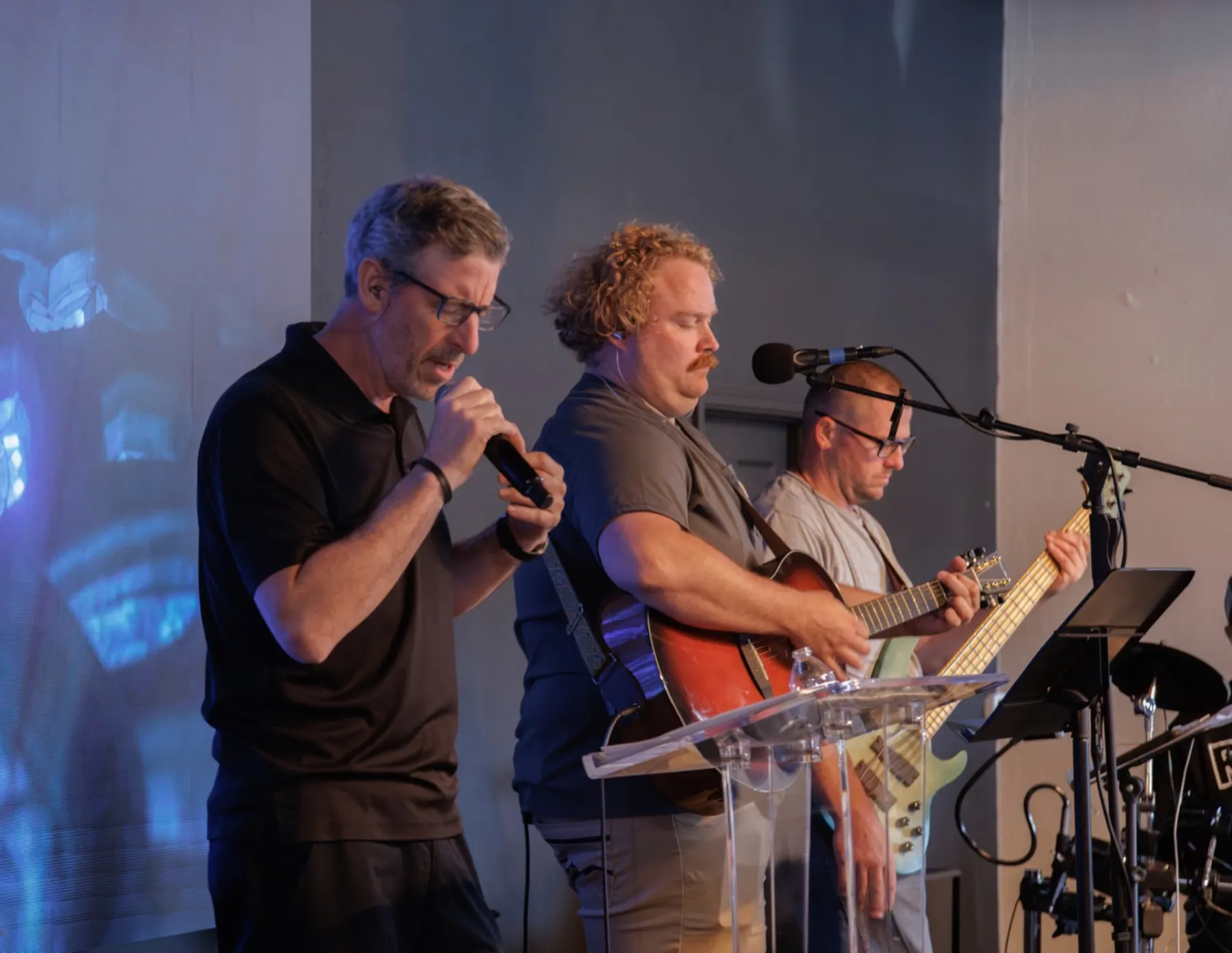 Three members of the River Northwest worship team singing together
